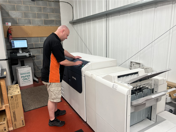 Team member Peter preparing printing machine prior to production of plan printing & scanning