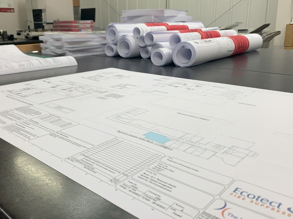 Professionally printed technical plans on the counter in The Print Rooms workspace in Bolton