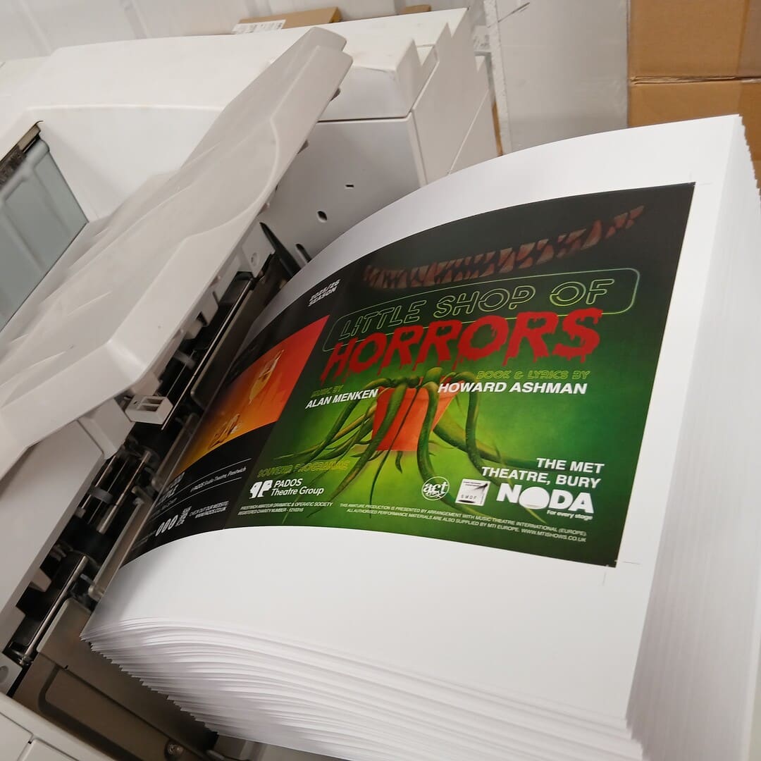 Pages of freshly printed Little Shop of Horrors theatre souvenir programmes on a print press in The Print Rooms unit
